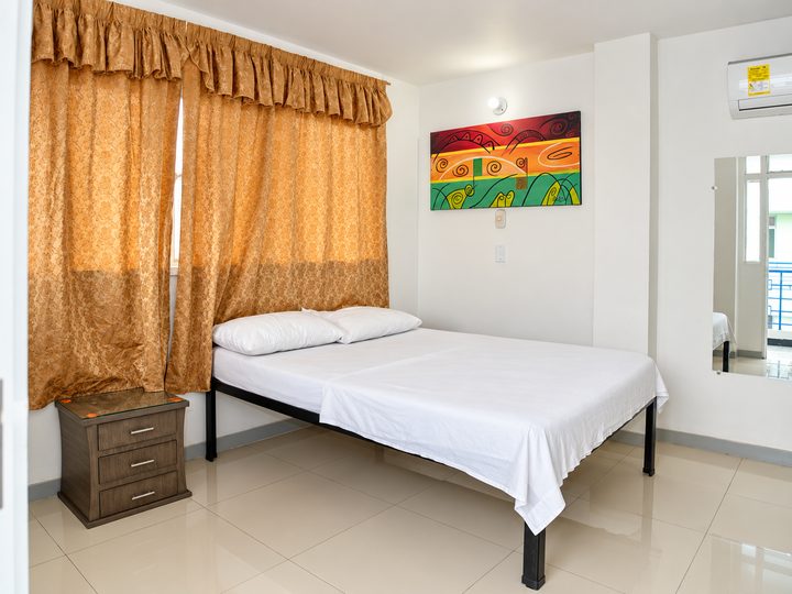Habitación con cama doble y cortinas doradas