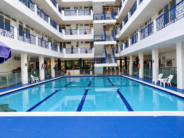 Piscina del patio central rodeada por los pisos del hotel